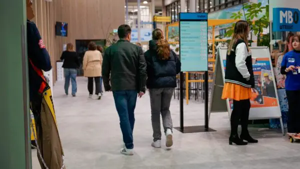 Studiekiezer en ouder lopen door de gang op een Open Dag