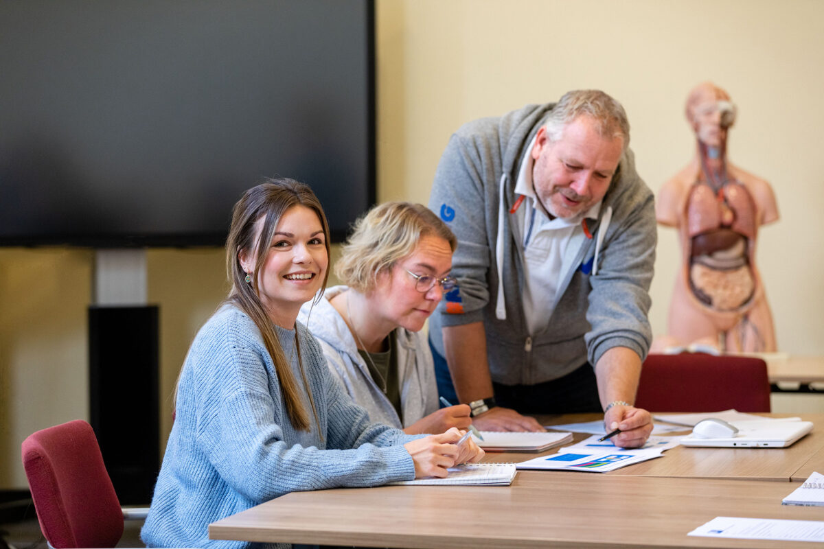 Studenten volwassenenonderwijs bespreken samen lesstof