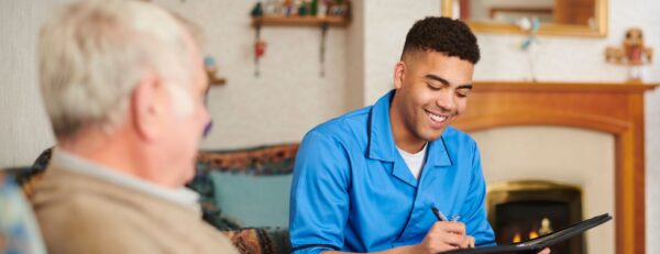 Helpende in gesprek met oudere man