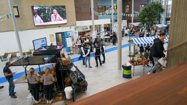 Docenten, bezoekers en studenten kletsen tijdens de Open Dag
