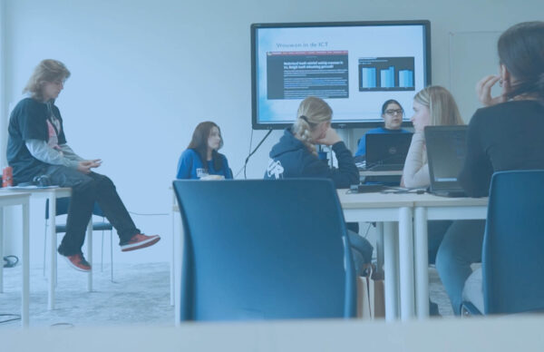 Thumbnail van een groep meiden die les krijg over ICT van een docent