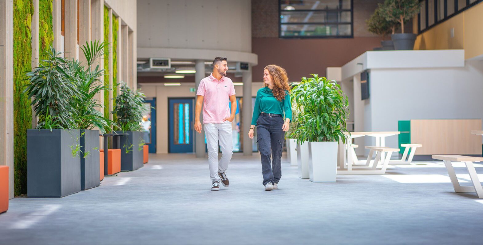 2 Studenten lopen over de gang op een locatie van MBO Utrecht tijdens een studiekeuze-event.
